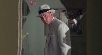 Movie still from “Mulholland Falls” (1996), directed by Lee Tamahori – A man in a suit and a hat is standing in front of a mirror; Close Up shot, Over the shoulder angle