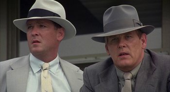 Movie still from “Mulholland Falls” (1996), directed by Lee Tamahori – A couple of men wearing hats and suits; Close Up shot, Low angle