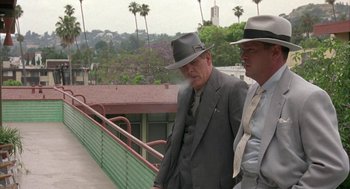 Movie still from “Mulholland Falls” (1996), directed by Lee Tamahori – A couple of men in suits and hats walking down a ramp; Medium shot, Low angle
