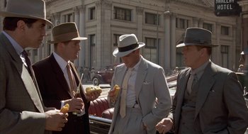 Movie still from “Mulholland Falls” (1996), directed by Lee Tamahori – A group of men standing next to each other on the street; Medium shot, Over the shoulder angle
