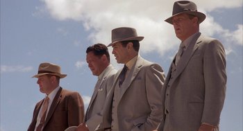 Movie still from “Mulholland Falls” (1996), directed by Lee Tamahori – A group of men in suits and hats standing next to each other; Medium shot, Low angle