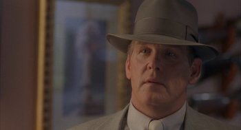 Movie still from “Mulholland Falls” (1996), directed by Lee Tamahori – A person wearing a suit and a hat; Close Up shot, Low angle