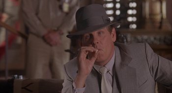 Movie still from “Mulholland Falls” (1996), directed by Lee Tamahori – A man in a suit and a hat smoking a cigarette; Close Up shot, Low angle