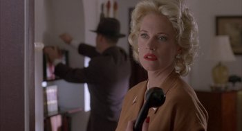 Movie still from “Mulholland Falls” (1996), directed by Lee Tamahori – A woman holding a phone in a room; Close Up shot, Low angle