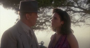 Movie still from “Mulholland Falls” (1996), directed by Lee Tamahori – A man and a woman standing next to each other in front of a tree; Close Up shot, Over the shoulder angle
