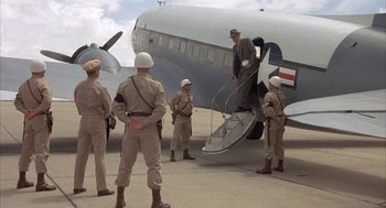Movie still from “Mulholland Falls” (1996), directed by Lee Tamahori – A group of men standing next to an airplane; Wide shot, Low angle