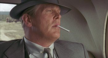Movie still from “Mulholland Falls” (1996), directed by Lee Tamahori – A person wearing a hat smoking a cigarette; Close Up shot, Low angle