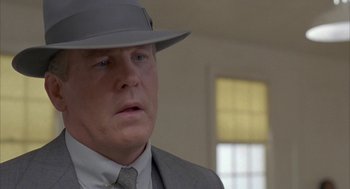 Movie still from “Mulholland Falls” (1996), directed by Lee Tamahori – A person wearing a suit and a hat; Close Up shot, Over the shoulder angle
