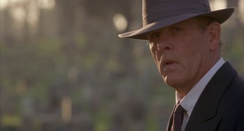 Movie still from “Mulholland Falls” (1996), directed by Lee Tamahori – A person wearing a hat and a tie; Close Up shot, Low angle