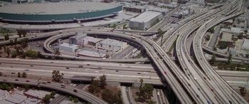 Movie still from “Multiplicity” (1996), directed by Harold Ramis – An aerial view of a freeway and a parking lot; Extreme Wide shot, High angle
