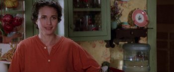 Movie still from “Multiplicity” (1996), directed by Harold Ramis – A woman standing in front of a cabinet in a kitchen; Close Up shot, Over the shoulder angle