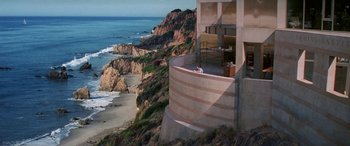 Movie still from “Multiplicity” (1996), directed by Harold Ramis – A view of the ocean from a building on a cliff; Extreme Wide shot, High angle