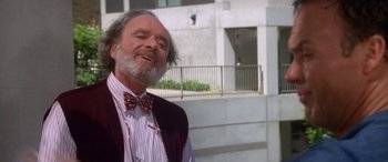 Movie still from “Multiplicity” (1996), directed by Harold Ramis – An older man wearing a vest and bow tie standing in front of a building; Close Up shot, Low angle
