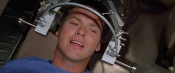 Movie still from “Multiplicity” (1996), directed by Harold Ramis – A man with his eyes closed in an x - ray machine; Close Up shot, Overhead angle