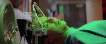 Movie still from “Multiplicity” (1996), directed by Harold Ramis – A man with his eyes closed in a green light; Close Up shot, Overhead angle