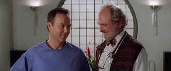 Movie still from “Multiplicity” (1996), directed by Harold Ramis – A couple of men standing next to each other; Close Up shot, Low angle