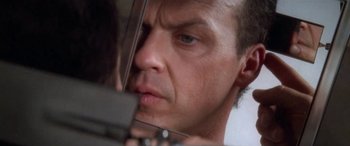 Movie still from “Multiplicity” (1996), directed by Harold Ramis – A man looking at his reflection in a mirror; Extreme Close Up shot, Low angle