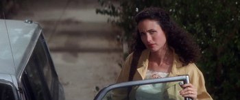 Movie still from “Multiplicity” (1996), directed by Harold Ramis – A woman standing next to a car on a street; Close Up shot, High angle