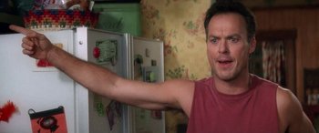 Movie still from “Multiplicity” (1996), directed by Harold Ramis – A man in a red shirt is pointing to a refrigerator; Close Up shot, Low angle