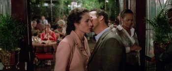 Movie still from “Multiplicity” (1996), directed by Harold Ramis – A man and a woman kissing each other in front of a crowd; Medium shot, Over the shoulder angle