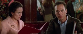 Movie still from “Multiplicity” (1996), directed by Harold Ramis – A man sitting at a table in front of other people; Close Up shot, Over the shoulder angle