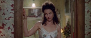 Movie still from “Multiplicity” (1996), directed by Harold Ramis – A woman in a negligee is posing for the camera; Close Up shot, Over the shoulder angle