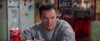 Movie still from “Multiplicity” (1996), directed by Harold Ramis – A person sitting at a table with a drink; Close Up shot, Over the shoulder angle