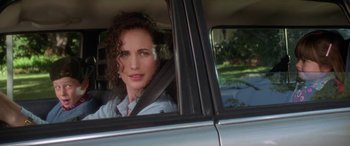 Movie still from “Multiplicity” (1996), directed by Harold Ramis – A woman sitting in the passenger seat of a car looking out of the window; Close Up shot, Over the shoulder angle
