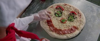 Movie still from “Multiplicity” (1996), directed by Harold Ramis – A person making a pizza with pepperoni , cheese , and peppers; Extreme Close Up shot, High angle