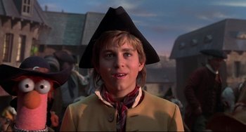 Movie still from “Muppet Treasure Island” (1996), directed by David Lane – A young man wearing a black hat and a yellow jacket; Close Up shot, Low angle