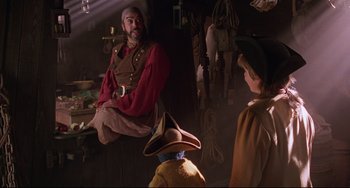 Movie still from “Muppet Treasure Island” (1996), directed by David Lane – A man sitting on top of a wall next to another man; Medium shot, Over the shoulder angle