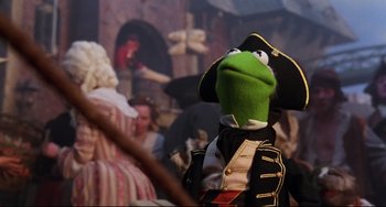 Movie still from “Muppet Treasure Island” (1996), directed by David Lane – A person dressed as kermit the frog wearing a pirate's outfit; Medium shot, Over the shoulder angle