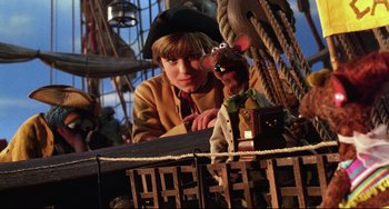 Movie still from “Muppet Treasure Island” (1996), directed by David Lane – A boy and a stuffed animal on a pirate ship; Medium shot, High angle