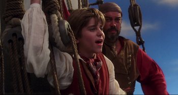Movie still from “Muppet Treasure Island” (1996), directed by David Lane – A young boy is singing on a pirate ship; Medium shot, Low angle