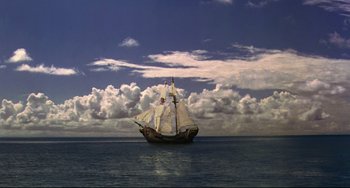 Movie still from “Muppet Treasure Island” (1996), directed by David Lane – A boat in the water under a cloudy sky; Extreme Wide shot, High angle