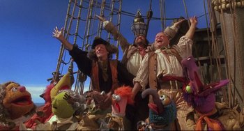 Movie still from “Muppet Treasure Island” (1996), directed by David Lane – A group of people standing next to each other on top of a boat; Wide shot, Low angle