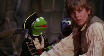 Movie still from “Muppet Treasure Island” (1996), directed by David Lane – A young boy and a muppet are dressed as pirates; Medium shot, Over the shoulder angle