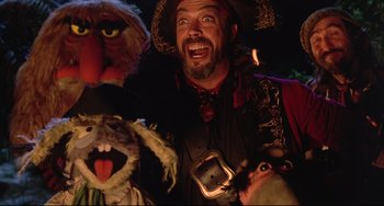 Movie still from “Muppet Treasure Island” (1996), directed by David Lane – A man in a pirate costume with a group of puppets; Medium shot, Low angle