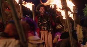Movie still from “Muppet Treasure Island” (1996), directed by David Lane – A man dressed as a pirate standing in front of fire; Medium shot, Over the shoulder angle