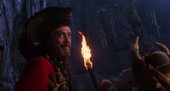 Movie still from “Muppet Treasure Island” (1996), directed by David Lane – A man in a pirate costume holding a burning torch; Medium shot, Low angle