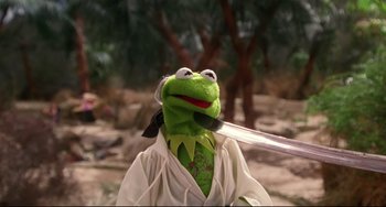 Movie still from “Muppet Treasure Island” (1996), directed by David Lane – A stuffed frog holding a baseball bat in its mouth; Medium shot, Low angle