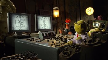 Movie still from “Muppets Most Wanted” (2014), directed by James Bobin – A couple of puppets sitting in front of a computer keyboard; Wide shot, High angle
