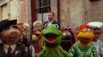 Movie still from “Muppets Most Wanted” (2014), directed by James Bobin – A group of muppets standing next to each other in front of a building; Medium shot, Over the shoulder angle