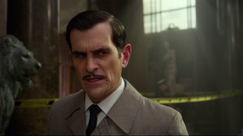 Movie still from “Muppets Most Wanted” (2014), directed by James Bobin – A person wearing a suit and tie; Close Up shot, Over the shoulder angle