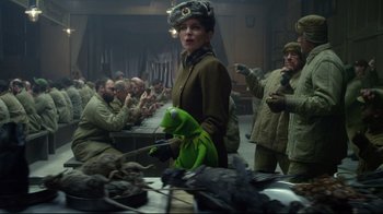 Movie still from “Muppets Most Wanted” (2014), directed by James Bobin – A group of people sitting around a table; Medium shot, Over the shoulder angle