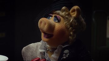 Movie still from “Muppets Most Wanted” (2014), directed by James Bobin – The face of a woman dressed as miss piggy from the muppets; Close Up shot, High angle