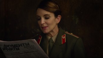 Movie still from “Muppets Most Wanted” (2014), directed by James Bobin – A woman in a military uniform reading a newspaper; Close Up shot, Over the shoulder angle