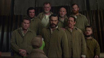 Movie still from “Muppets Most Wanted” (2014), directed by James Bobin – A group of men standing next to each other; Medium shot, Over the shoulder angle