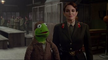 Movie still from “Muppets Most Wanted” (2014), directed by James Bobin – A woman in a uniform standing next to a man in a suit; Medium shot, Over the shoulder angle