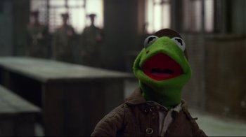 Movie still from “Muppets Most Wanted” (2014), directed by James Bobin – A person wearing a kermit the frog mask; Close Up shot, Over the shoulder angle
